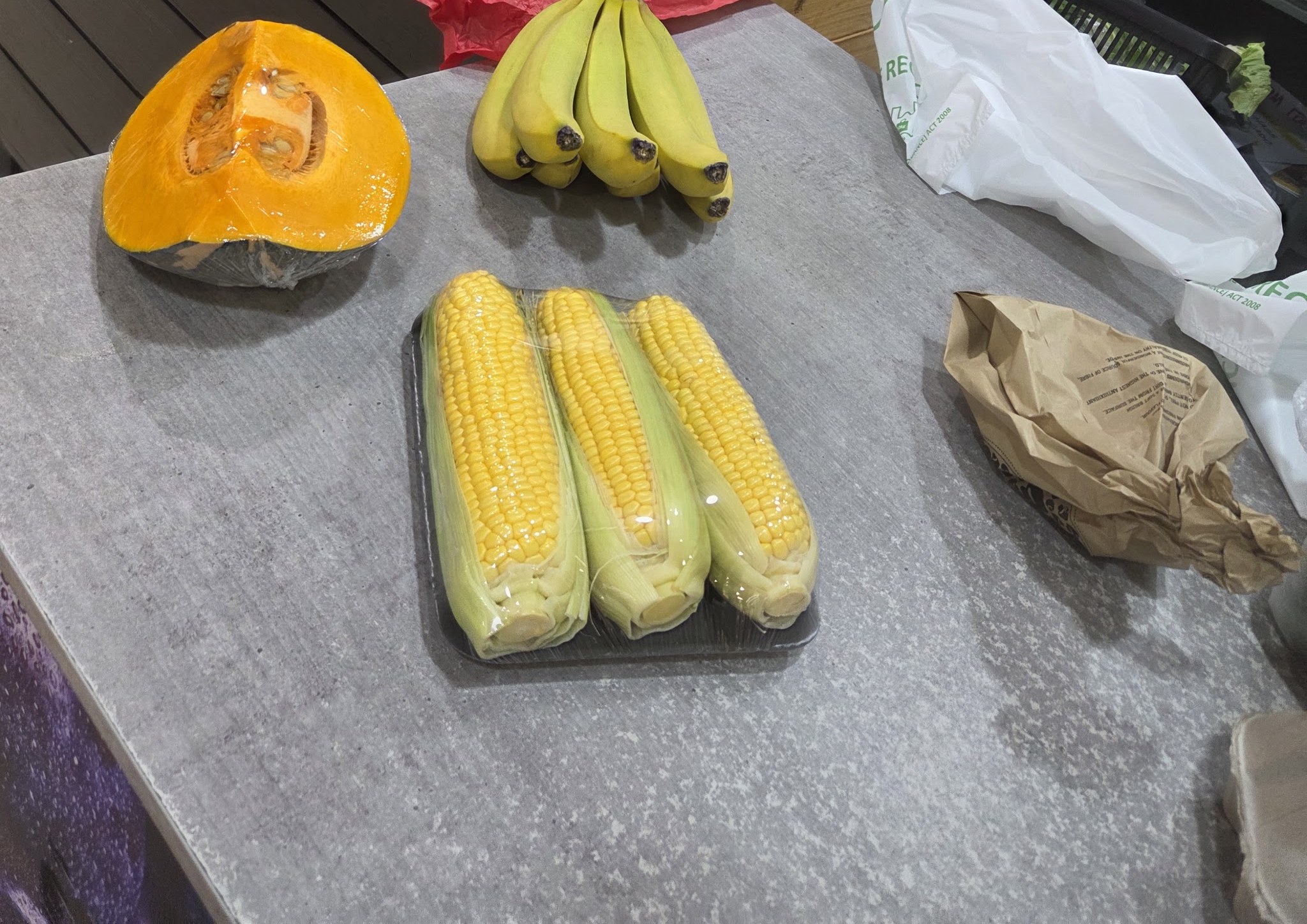 Pumpkin, bananas and sweet corn on the counter